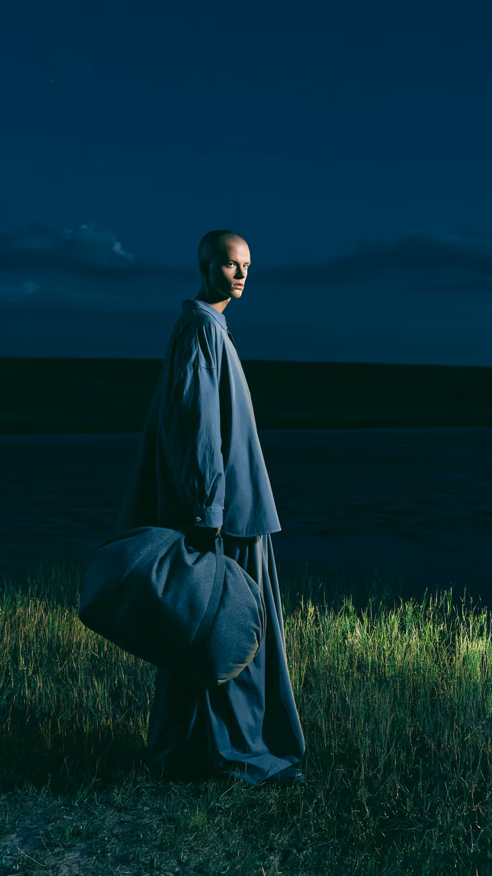 Full-body fashion editorial at night with blue styling