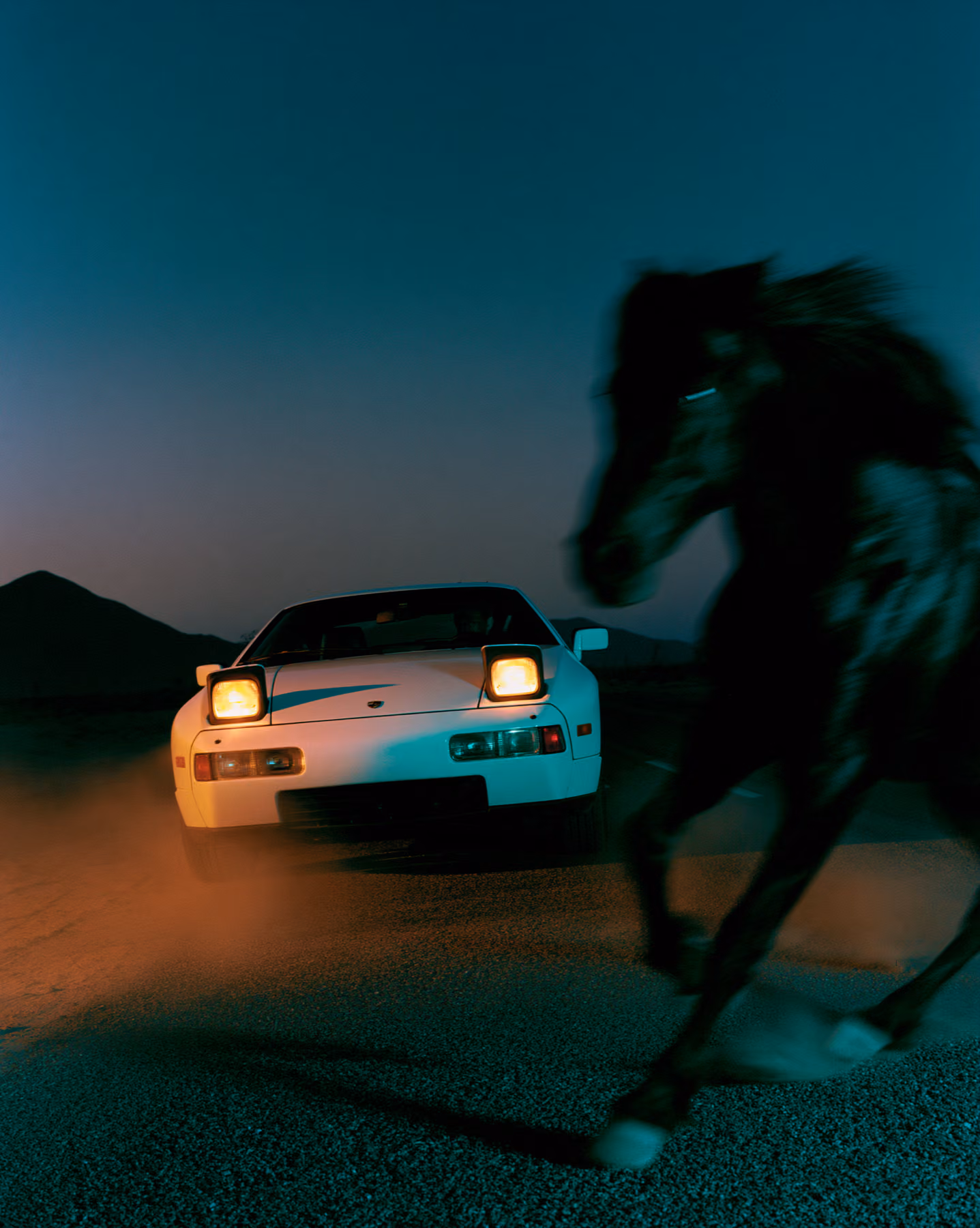 Cinematic night frame with a sports car and blurred black horse
