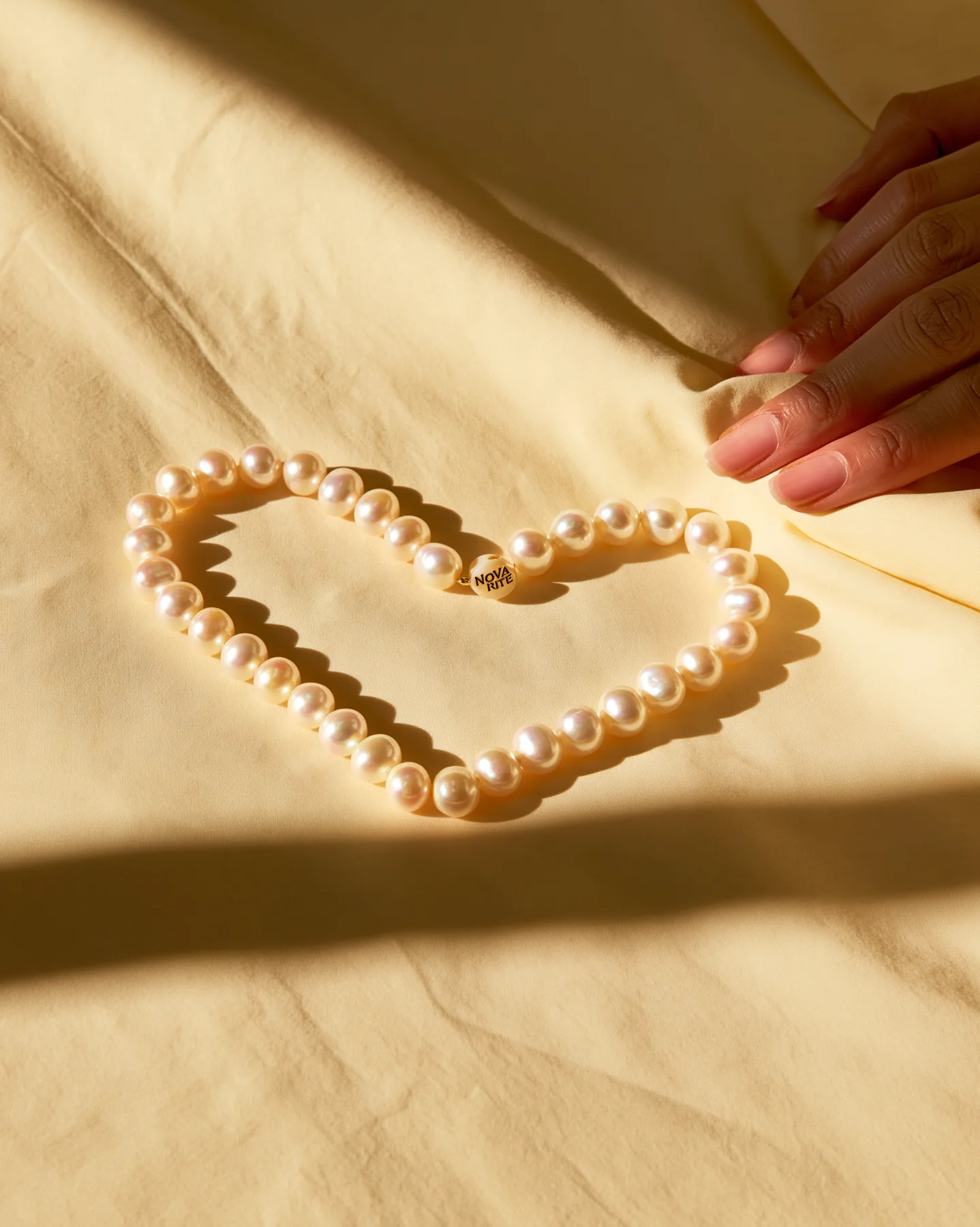 Pearl necklace campaign image arranged on silk fabric
