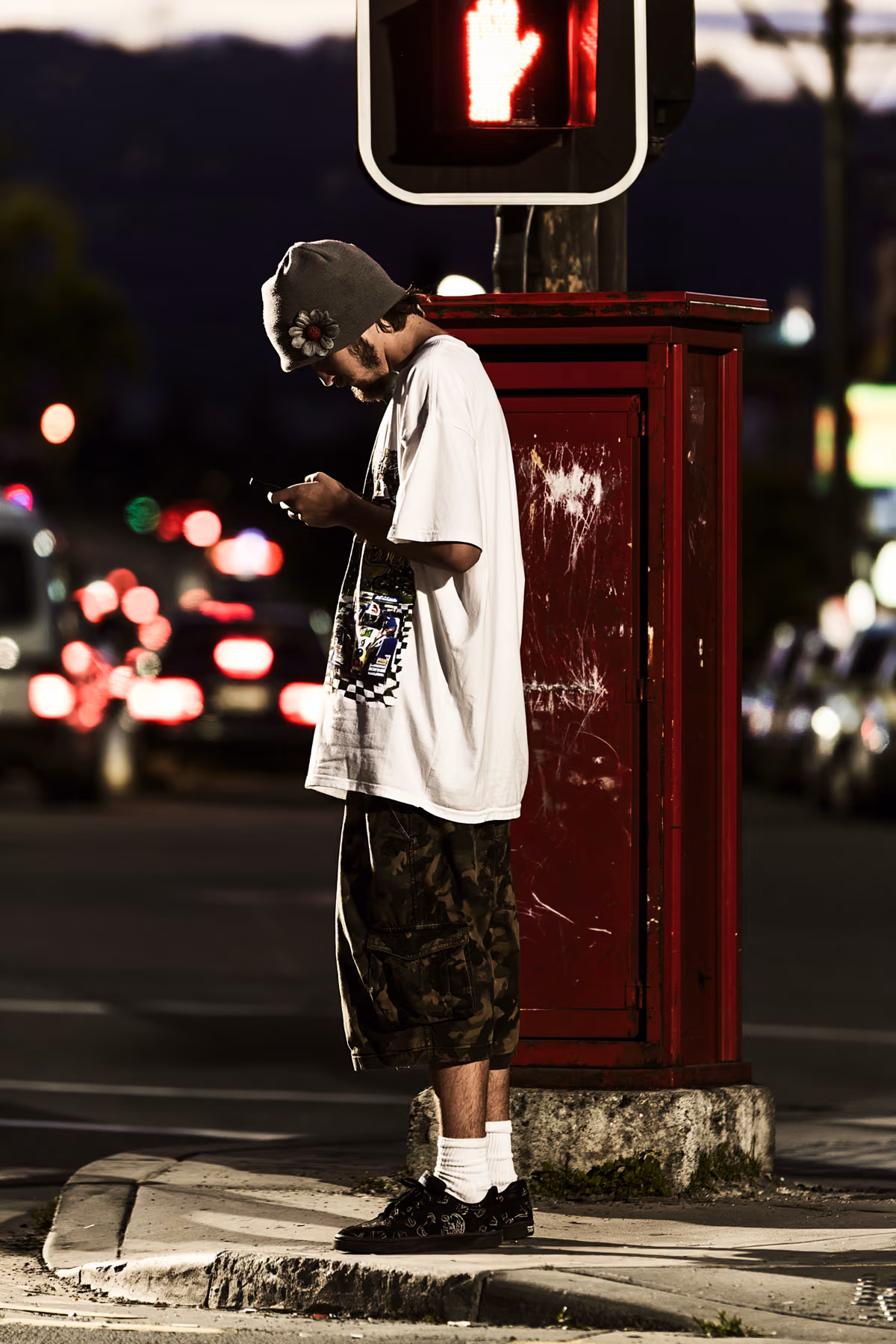Streetwear portrait near a red traffic signal at night