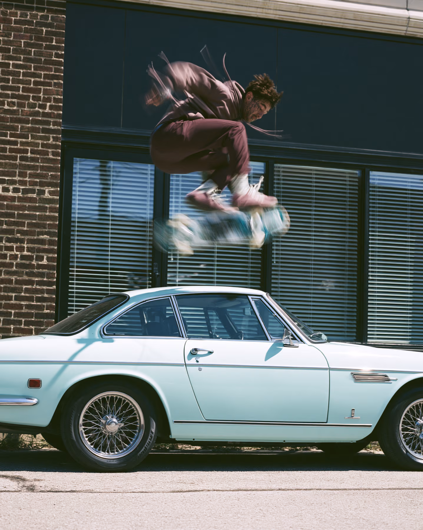 Streetwear skater jumping over a vintage car