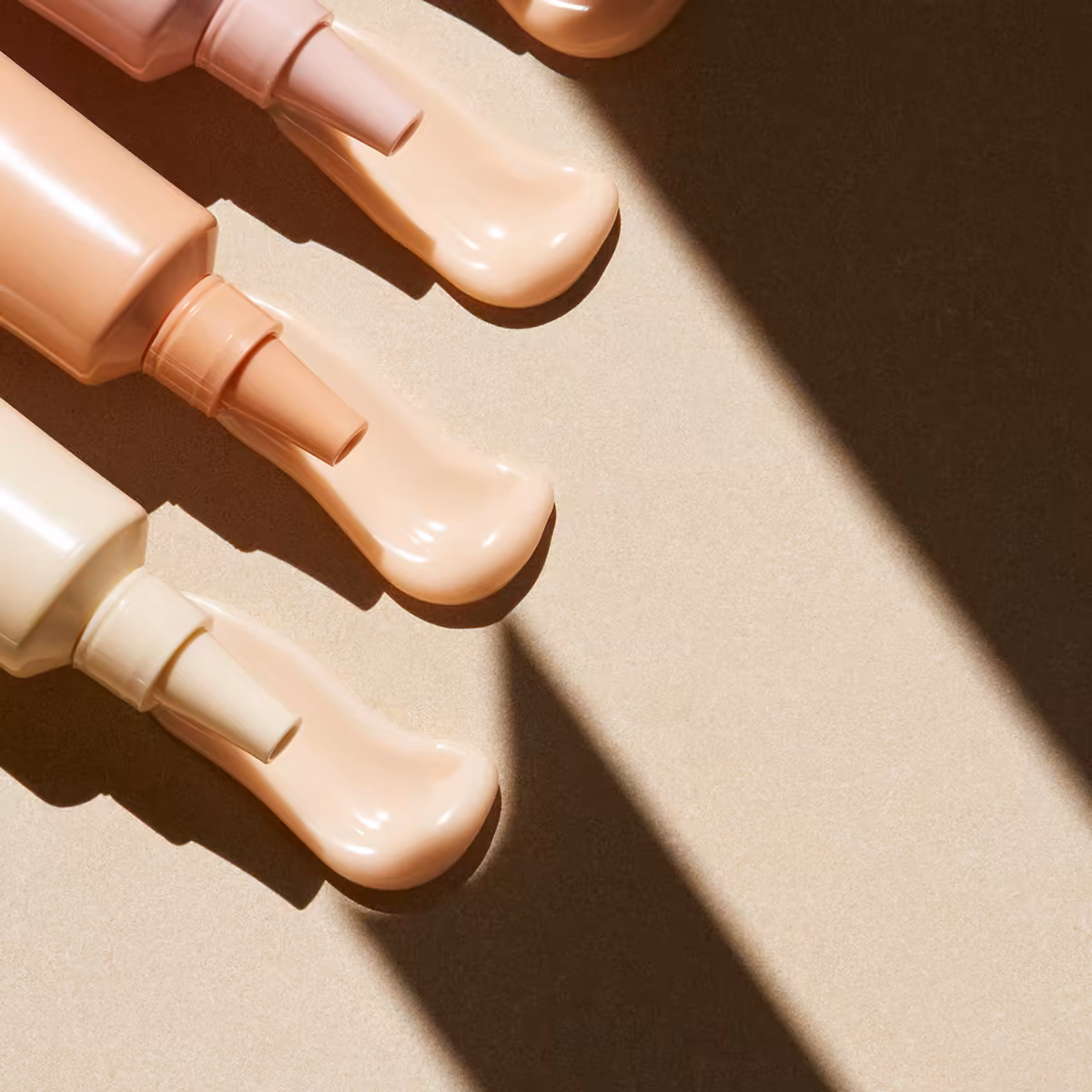Overhead skincare still life with cosmetic swatches and hard sunlight