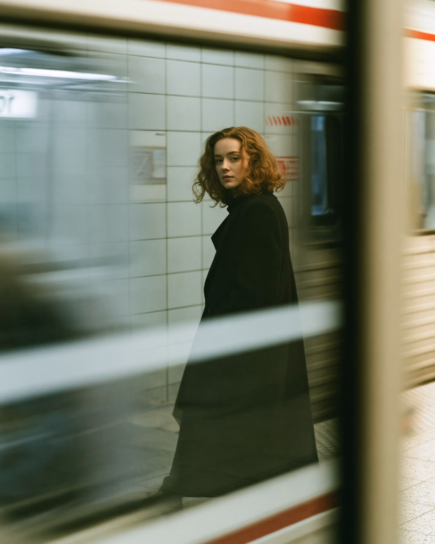 Cinematic fashion portrait seen through a subway train window