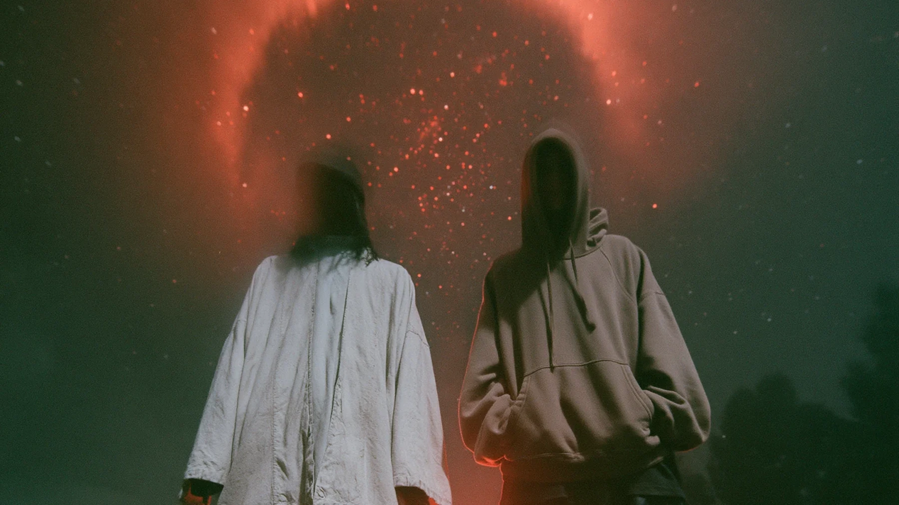 SEN lookbook wide frame with two figures facing red rain over wet concrete